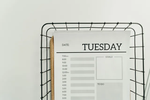 Top view of a minimalist Tuesday planner on a wire basket for organization and scheduling. Add business days: three start conventions and fifteen worked cases excluding the start