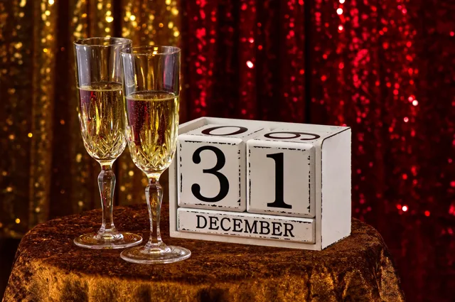 Elegant New Year's Eve table setting with champagne glasses and December 31 calendar block. Federal Holiday Business Day Counting: Project Dates