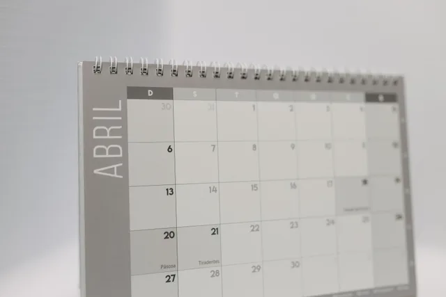Close-up of a spiral-bound April desk calendar with a gray minimalistic design. Days between dates in Excel: subtraction, times, DATEDIF and NETWORKDAYS