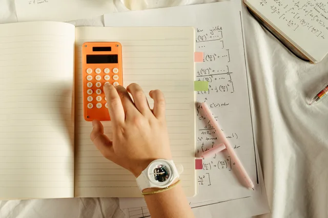 A student calculates math equations using an orange calculator and notebook for study. Notes on working days per month in Excel: NETWORKDAYS, EOMONTH and month edges